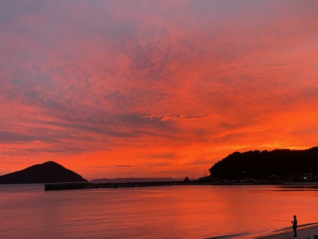 福の浦の夕陽が海をピンク色に染める夕景