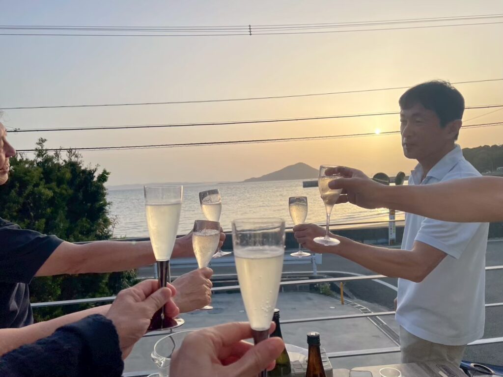 糸島・福の浦のオーシャンビューヴィラ「海と夕陽Turquoise Serenity」のオーシャンデッキで潮騒をBGMに電気式BBQグリルで焼き肉を楽しむ様子