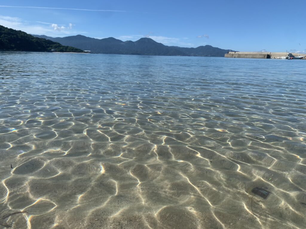 糸島・福の浦の透明な浅瀬に太陽が反射して輝く海面