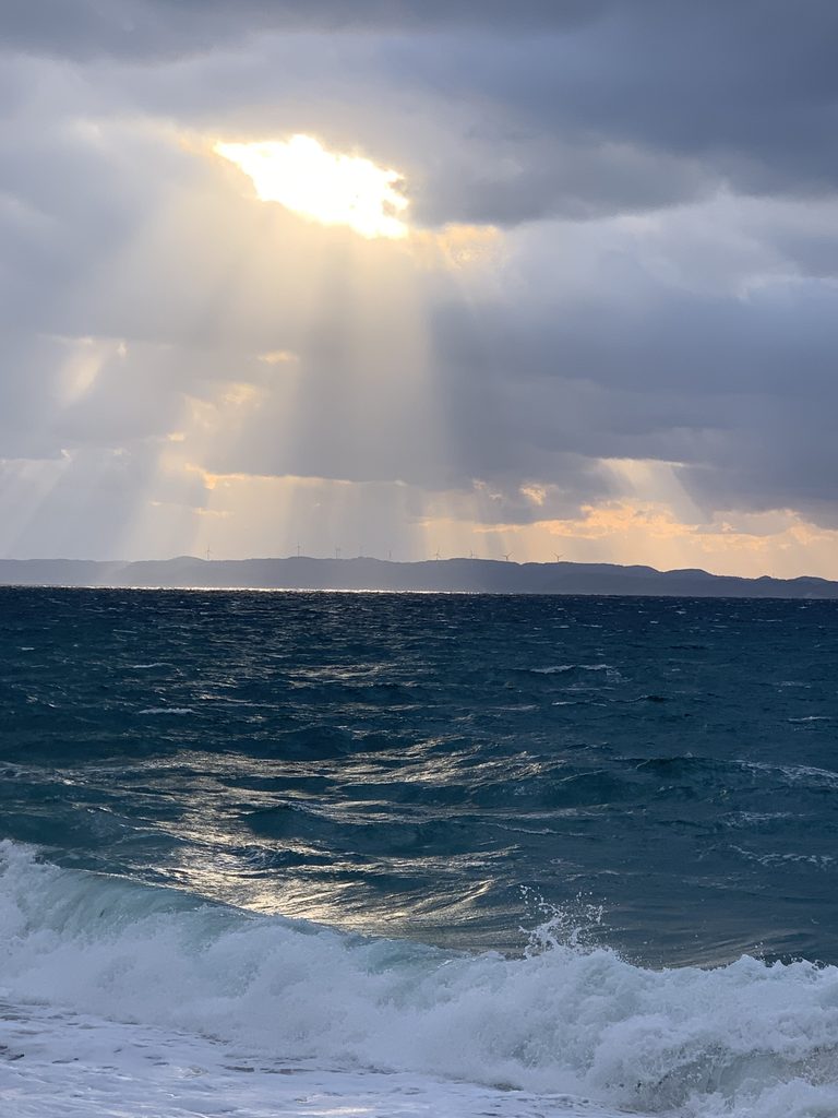 玄界灘の海面を照らす雲間からの光と天使の梯子